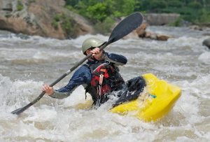 Kayaker fighting the rapids of a river.